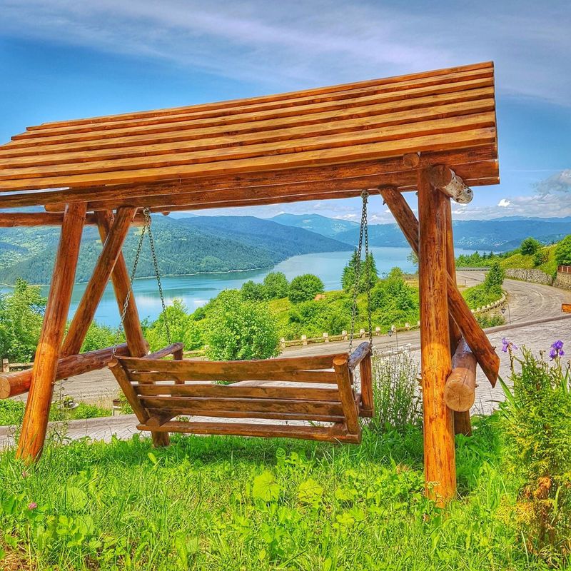 Leagăn din lemn cu vedere spre lac
